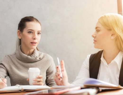 2 Business Women Sitting at a Conference Table